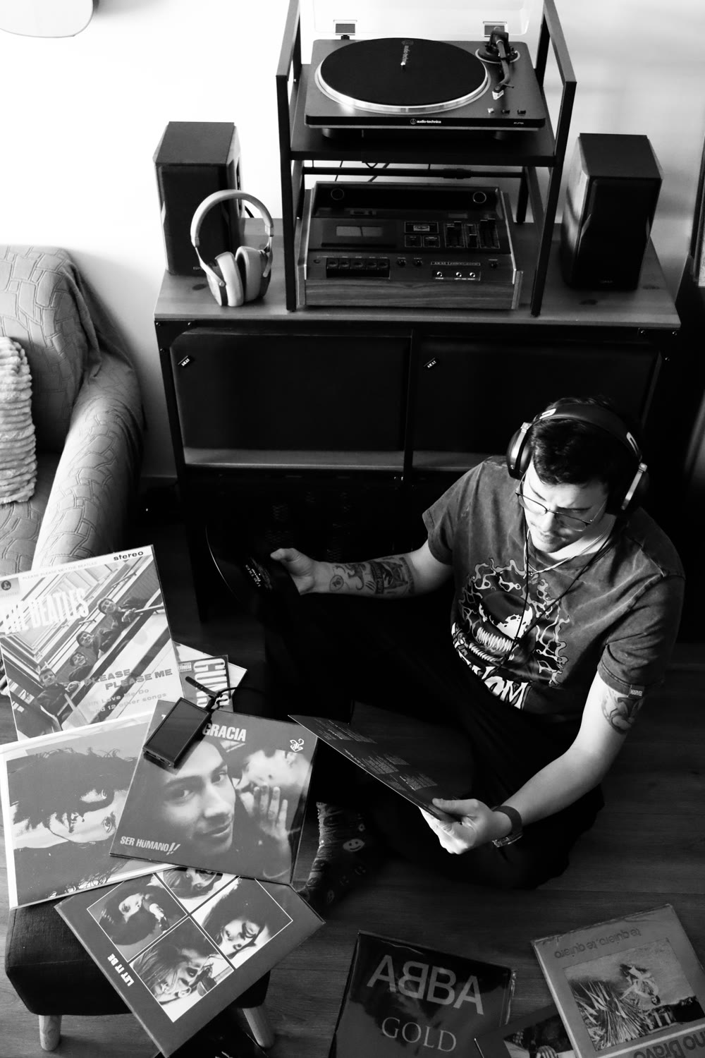 Gus sentado en el piso rodeado de su colección de vinilos — Beatles, ABBA, discos chilenos y latinos